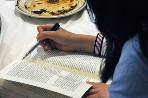 Closeup of a student in 2018 reading a book.