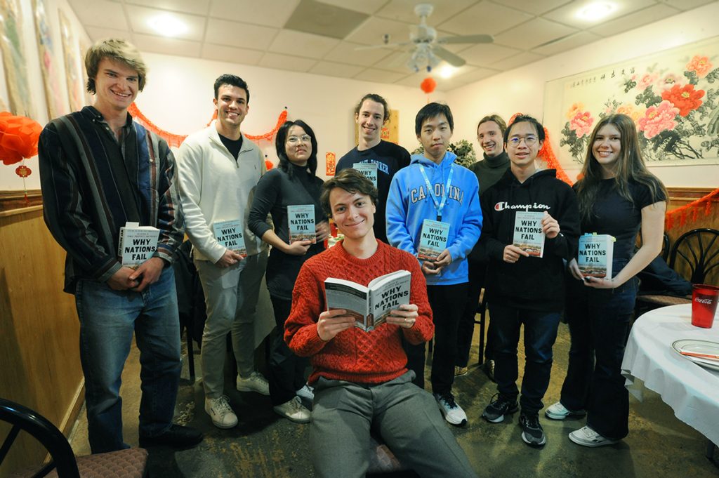 PPE reading group leader and graduate student Will Kanwischer (kneeling, front row), with, from left, Andrew Schuler, Christopher Westcott, Willow Yang, Liam Cuppett, Luming Jia, Zach Kingery, Matseoi Zau and Micah Mangot at Gourmet Kingdom. (photo by Donn Young)

