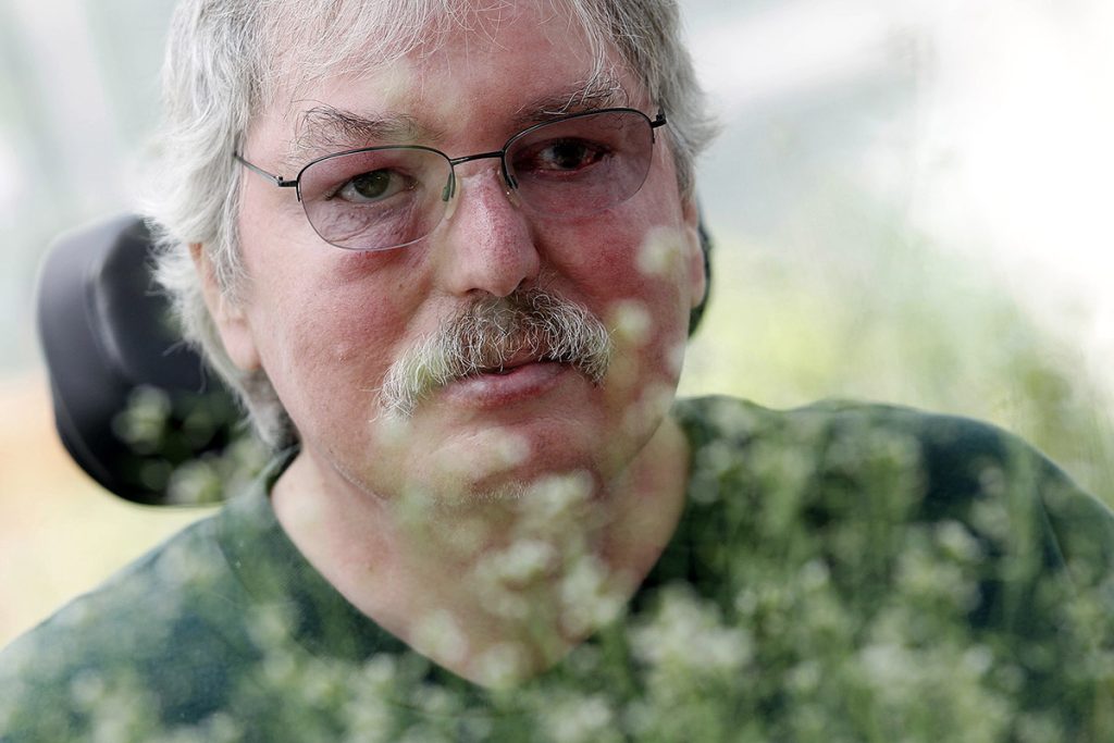 Closeup of Jeff Dangl surrounded by plants.