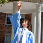 Anthony tosses his cap for a graduation photo at the Old Well